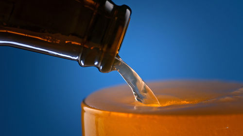 Close-up of drink in glass against blue background