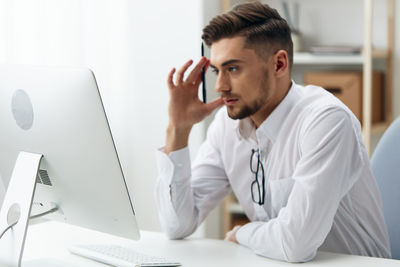 Young woman using mobile phone in office