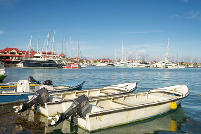 Simple old fishing boats and luxury yachts in background  at marina of eden island, mahe, seychelles
