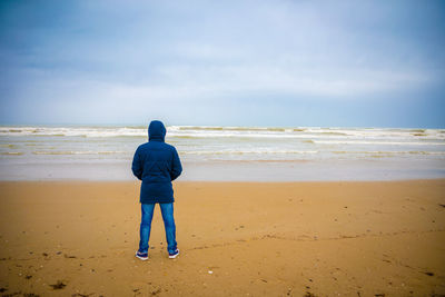 Rear view of man standing on beach