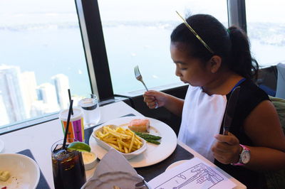 Girl looking at meal on table in restaurant