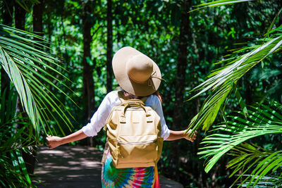 Rear view of boy standing by tree