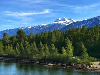 Scenic view of lake by mountains against sky