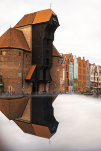 Ancient crane - zuraw old town in gdansk. the riverside on granary island reflection in moltawa