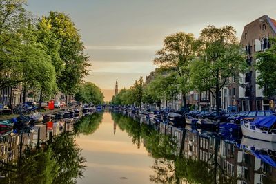 Boats moored in canal against sky