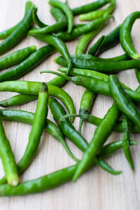 Fresh green chili pepper on plain wooden table, green essential vegetables for all essential foods