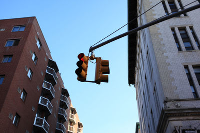 Low angle view of road signal against buildings in city