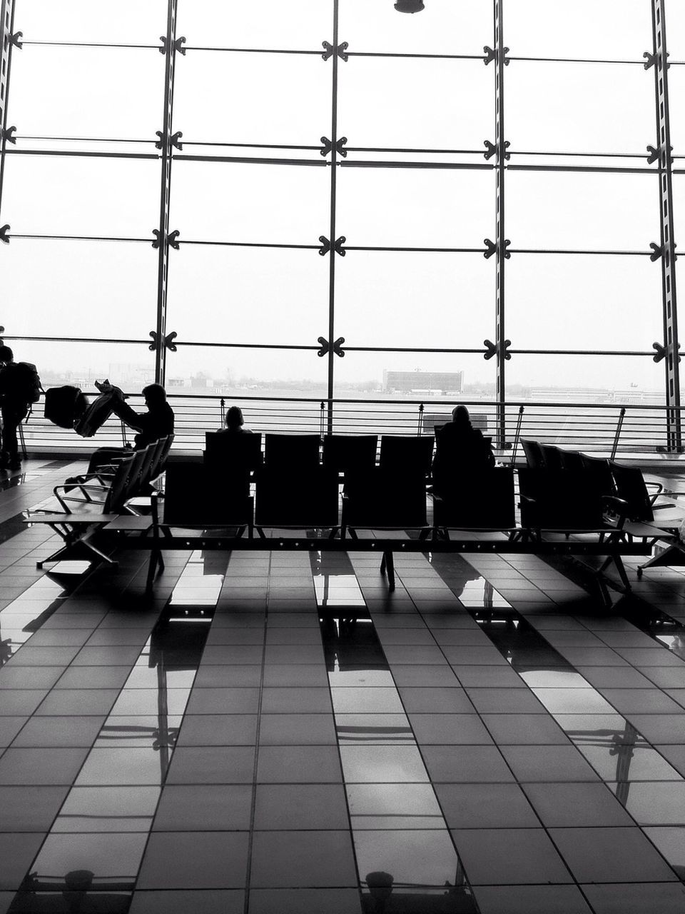 indoors, chair, table, window, tiled floor, glass - material, office, empty, restaurant, transparent, modern, airport, reflection, absence, sitting, seat, in a row, flooring, men, built structure