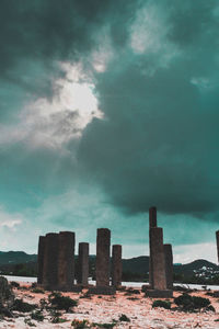 Buildings by sea against storm clouds