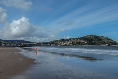 Two people on beach against sky