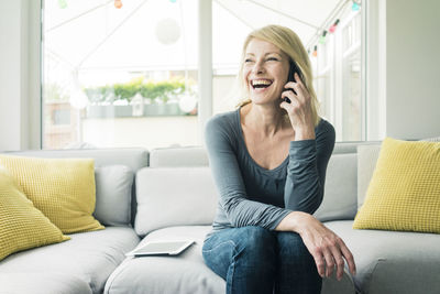 Happy woman on the phone on couch