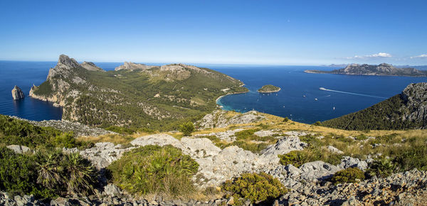 Scenic view of bay against clear blue sky