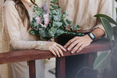 Midsection of bride holding bouquet
