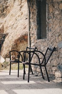 Empty chair against wall of old building