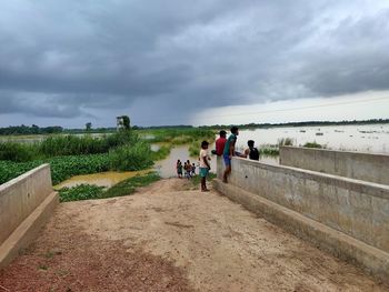 People on footpath against sky