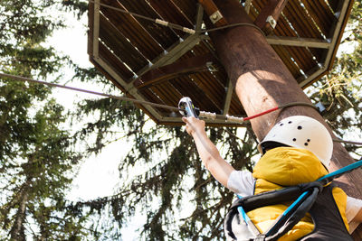 Rear view of boy preparing for zip line