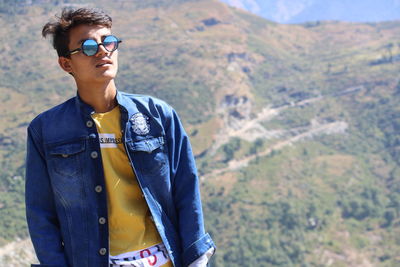 Portrait of young man wearing sunglasses standing outdoors