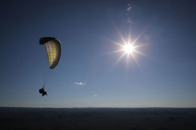 Low angle view of person paragliding against clear sky