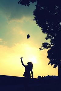 Silhouette man playing soccer against sky during sunset