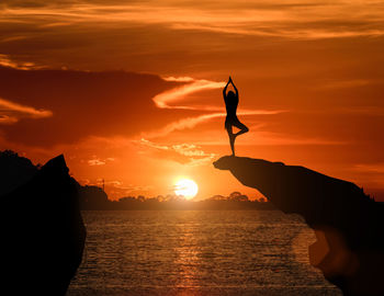 Silhouette man standing by sea against sky during sunset