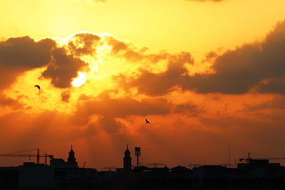 Silhouette buildings against sky during sunset