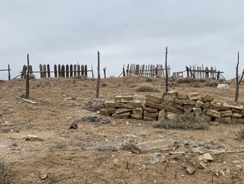 Wooden posts on field against sky