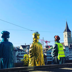 Rear view of statue against blue sky in city