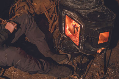 Camping in winter. warming up with a wood stove on a cold night.