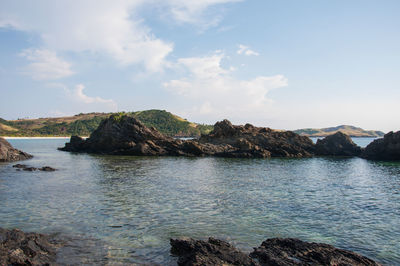 Scenic view of rocks in sea against sky