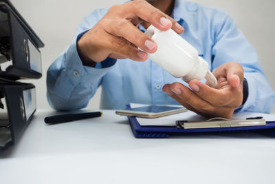 Midsection of man holding hands on table