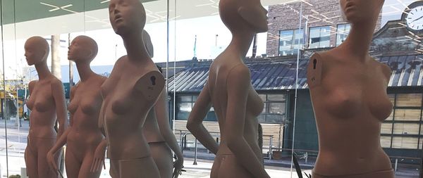 Mannequins against glass window in shop