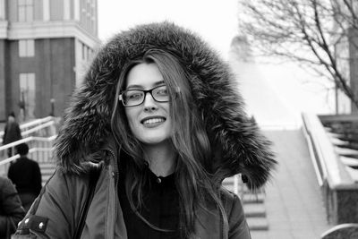 Portrait of beautiful young woman in city during winter