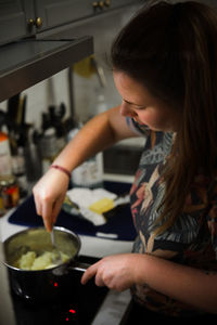 Midsection of woman having food at home