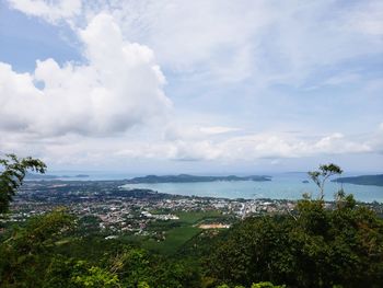 Aerial view of city by sea against sky