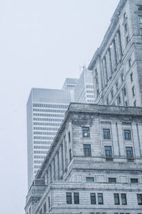 Low angle view of buildings against clear sky in city