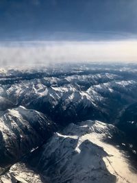 Aerial view of snowcapped mountains against sky