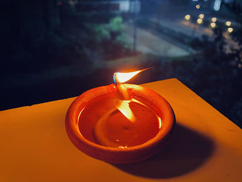Close-up of lit tea light candles on table