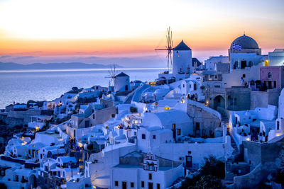 Houses by sea during sunset at santorini