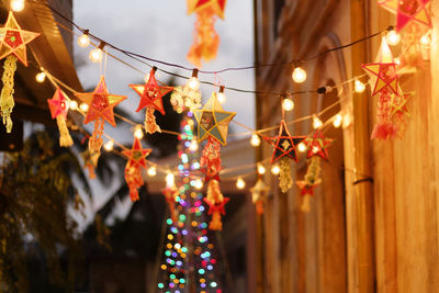 Low angle view of illuminated lanterns hanging on christmas lights