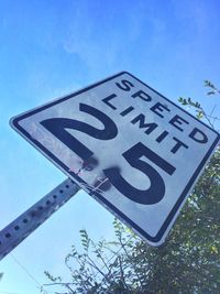 Low angle view of sign board against blue sky