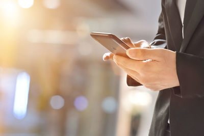 Midsection of man using mobile phone