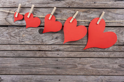 High angle view of red heart shape on wooden table