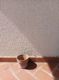 High angle view of coffee cup on floor against wall