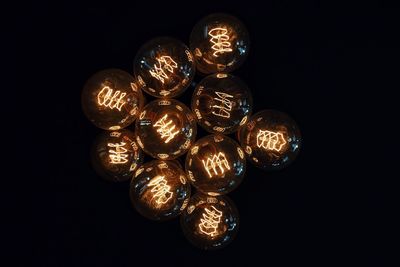 Close up of illuminated light bulbs against black background