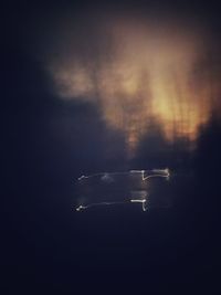 Aerial view of illuminated car windshield against sky at night