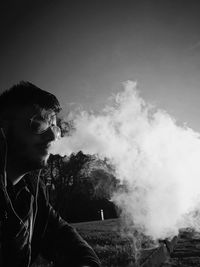 Man smoking against clear sky