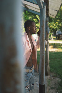 Side view of young man looking away outdoors