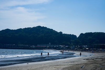 People on beach against sky