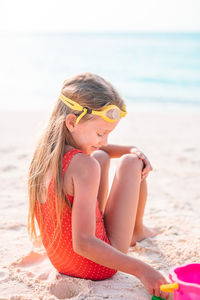 Midsection of woman sitting on beach