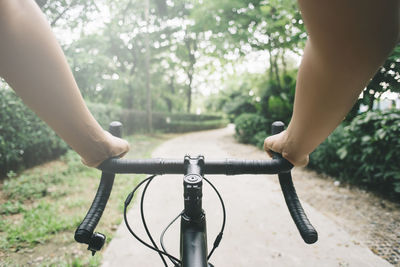 View of bicycle handle bar againts nature path park person